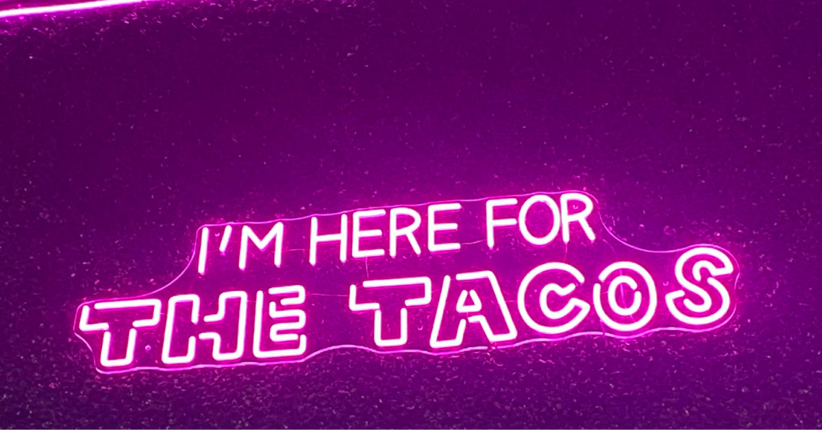 neon sign that reads "im here for the tacos"